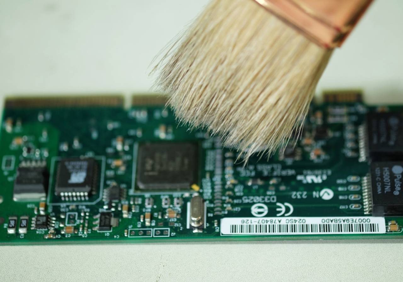 close-up de placa de circuito sendo limpada com pincel