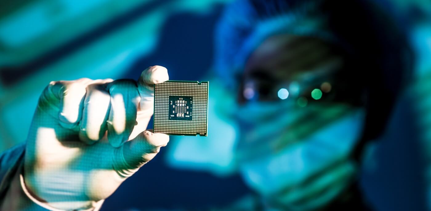 Técnico de laboratório segurando uma CPU (chip).