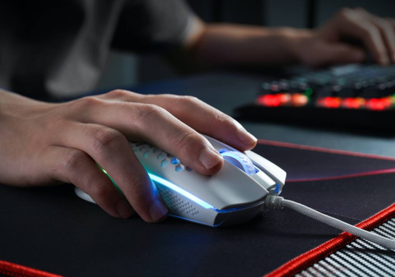close-up de menino jogando com mouse em cima do mousepad gamer