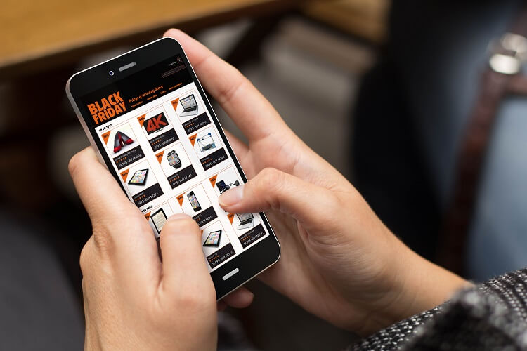 Homem segurando celular na tela um e-commerce na black friday