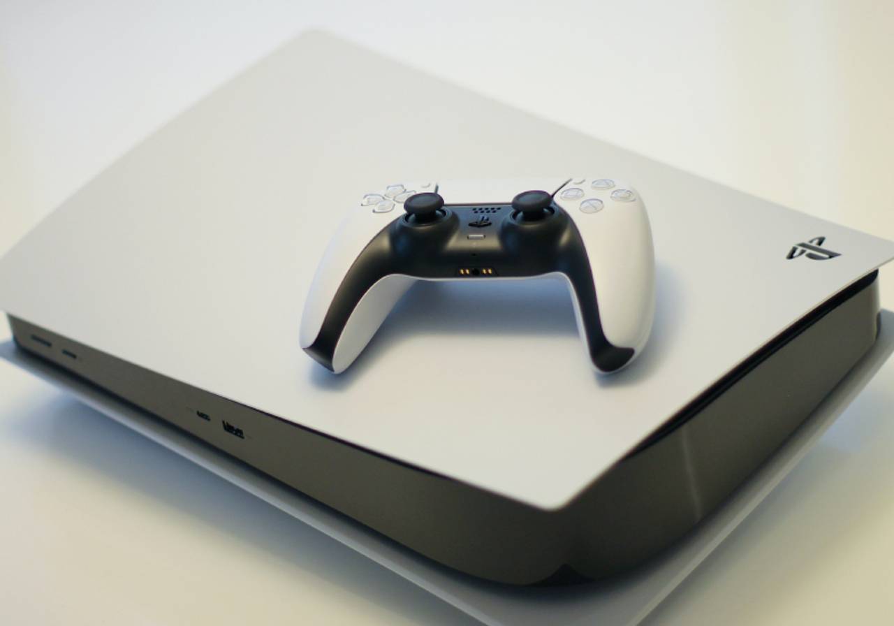 playstation 5 com controle em cima em fundo branco 