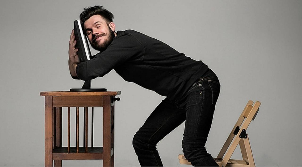 Homem abraçando o computador