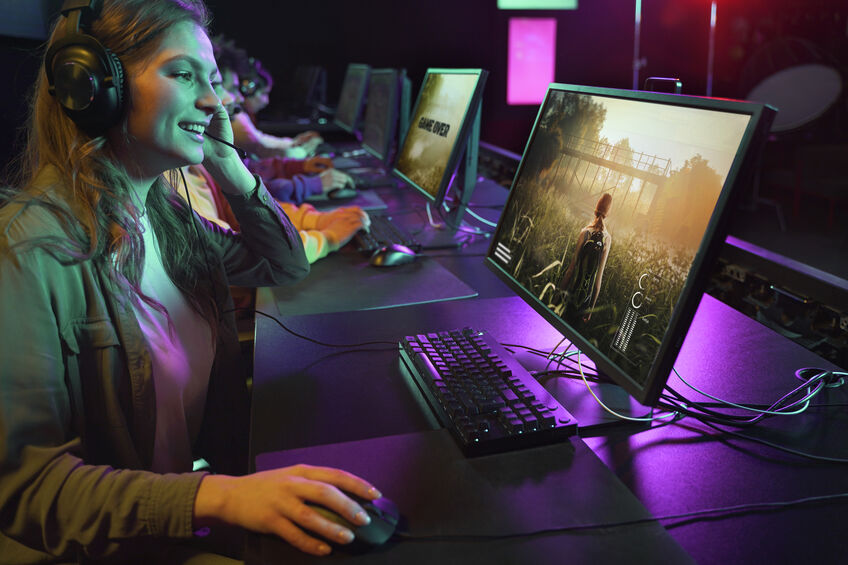 Mulher jogando no computador com fone de ouvido