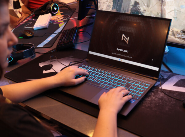 Pessoa usando o Notebook Neologic Journey com luz de fundo em ambiente gamer.