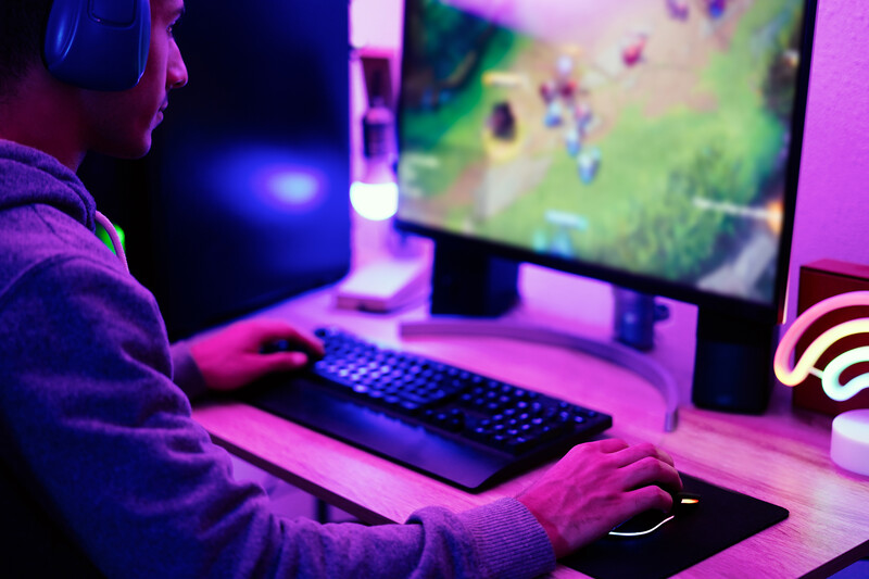 Jovem jogando no computador à noite