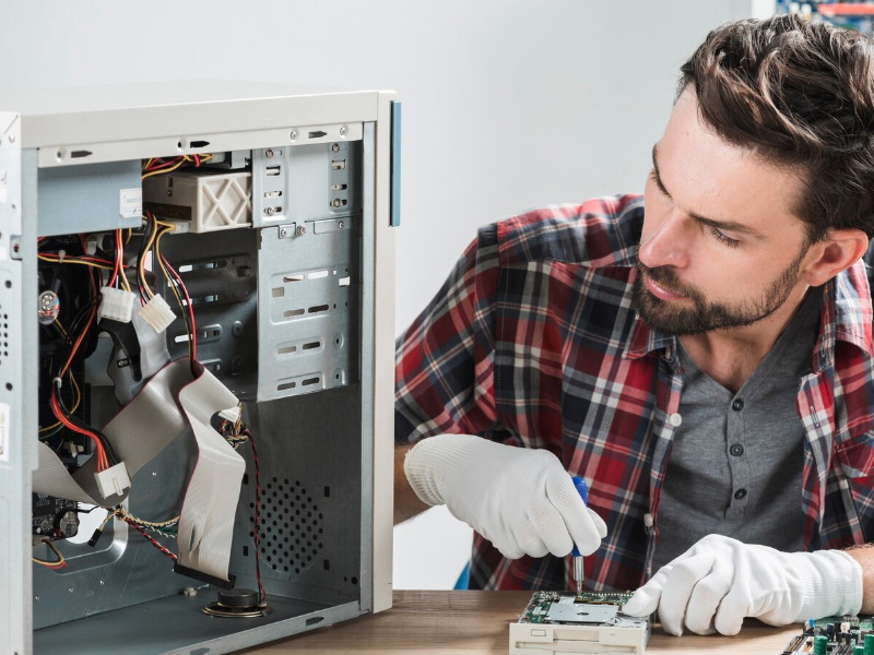 Técnico de informática trabalhando em gabinete aberto de computador na assistência técnica da Shopinfo em Campinas.